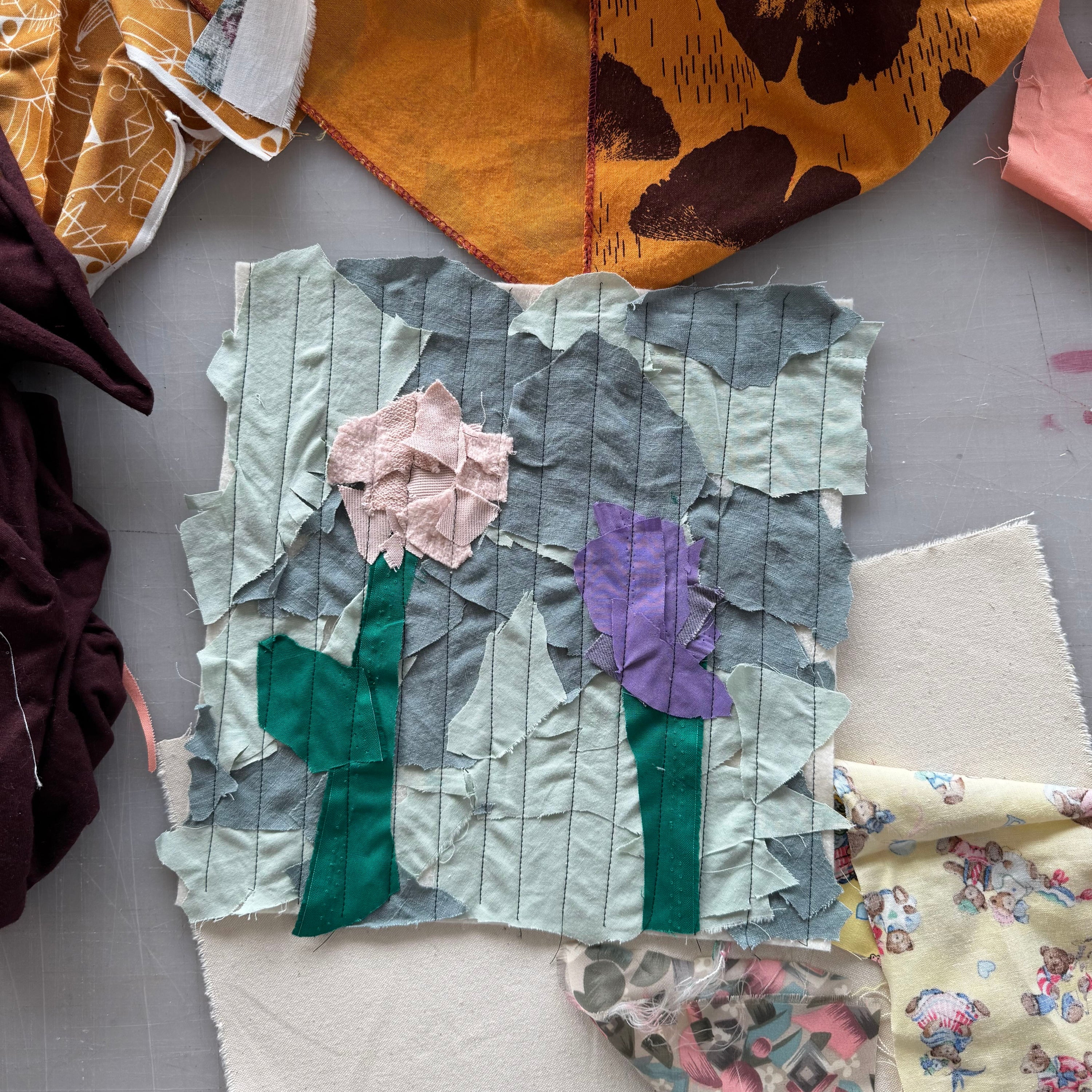 Fabric swatches with floral and abstract patterns on a gray surface