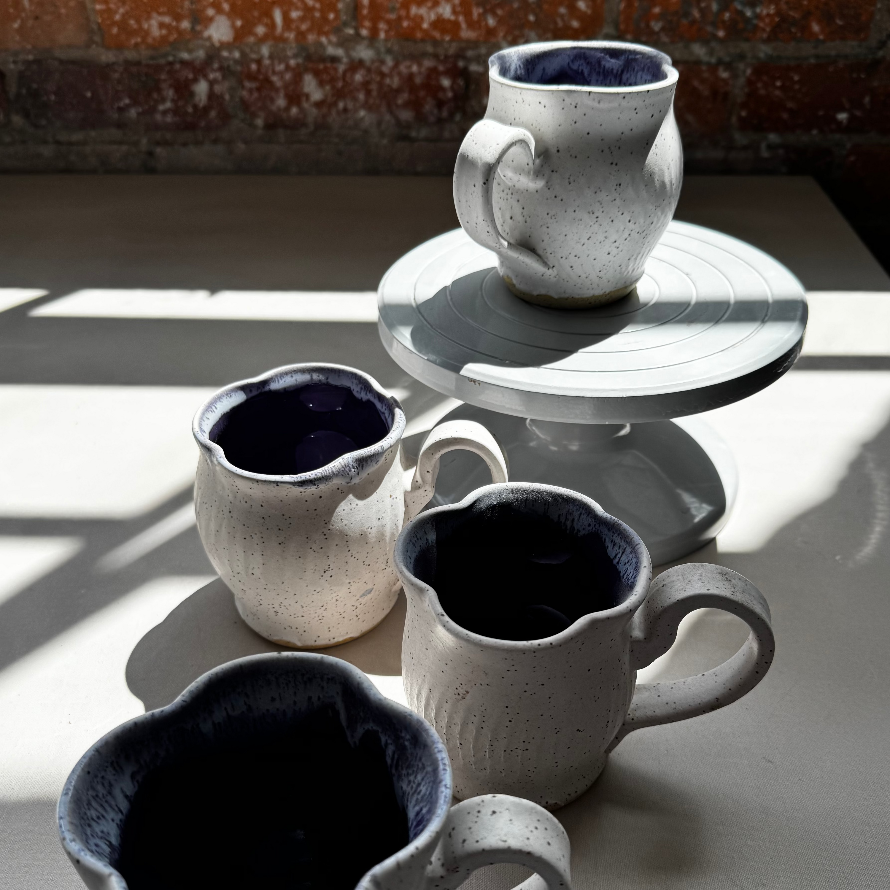 Set of ceramic cups on a table with a brick wall background